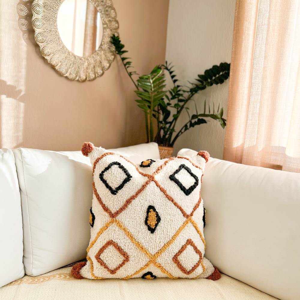 Hand-tufted Samya cushion cover featuring a thick terracotta diamond lattice, black geometric borders, and mustard accents on a cream canvas.
