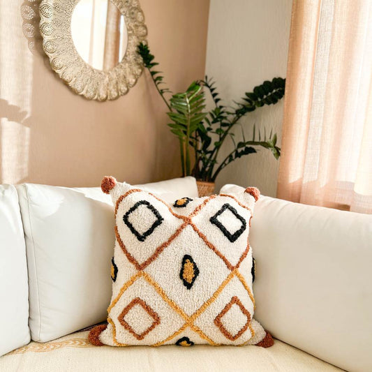 Hand-tufted Samya cushion cover featuring a thick terracotta diamond lattice, black geometric borders, and mustard accents on a cream canvas.